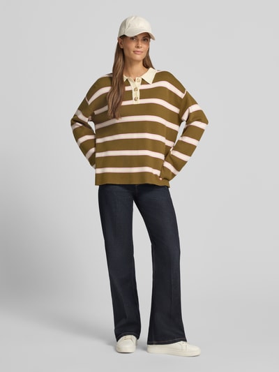 Frauenmodel trägt Pullover aus Viskose-Mix mit Polokragen Modell 'ISABELL' von YAS, gestreift in Oliv, Beige und Weiß, Loose Fit, Ganzkörperansicht von vorne.