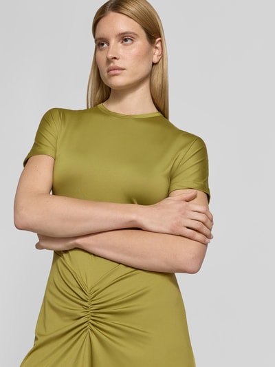 Frauenmodel trägt Midikleid mit Raffungen von Victoria Beckham in Olivgrün, elastischer Material-Mix, taillierte Passform, Nahaufnahme Oberkörper.