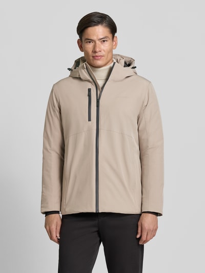 Męski model nosi Regular Fit Jacke mit Logo-Print od Lindbergh, elastyczna mieszanka materiałów, kaptur z tunelem, nadruk z logo, napoleońska kieszeń, długość tyłu w rozmiarze M: 74 cm, szerokość ramion w rozmiarze M: 46 cm, szerokość klatki piersiowej w rozmiarze M: 42 cm, długość rękawów w rozmiarze M: 62 cm, beżowy kolor, proste kształty, gładka faktura, widok całej sylwetki z przodu.