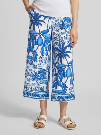 Vrouwenmodel draagt Culotte uit viscosemix met elastische band van Christian Berg Woman, blauw-wit tropisch motief, steekzakken, los model, binnenbeenlengte 61 cm, bandwijdte 39 cm, maat 36, vooraanzicht, detailopname.