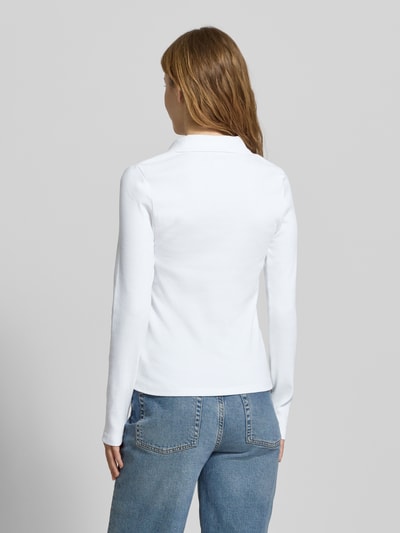Modelka nosi Longsleeve mit Label-Detail od Calvin Klein Jeans, bawełna z domieszką elastanu, krój slim fit, widok całej sylwetki z tyłu.