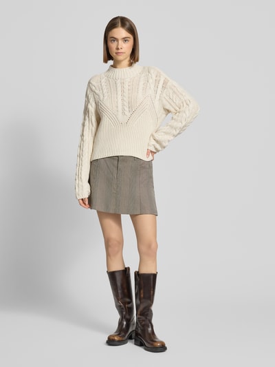 Frauenmodel trägt Slim Fit Pullover in Strick-Optik Modell 'Haysa' von Noisy May aus Baumwoll-Mix mit Rundhalsausschnitt, Beige-Ton, feine eingewebte Musterstruktur, eingefasste Ärmelabschlüsse, Rückenlänge 58 cm, Ärmellänge 67 cm, Ganzkörperansicht von vorne.