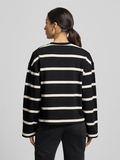 Frauenmodel trägt Relaxed Fit Sweatshirt aus Baumwoll-Mix von Tommy Hilfiger mit schwarz-weißen Streifen und Logo-Stitching, Ganzkörperansicht Rückansicht.