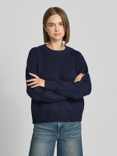 Vrouwenmodel draagt donkerblauwe gebreide pullover met opgestikte zak Model 'FRANKIE' van Topshop, relaxed fit, met wol, nahaufnahme bovenlichaam.