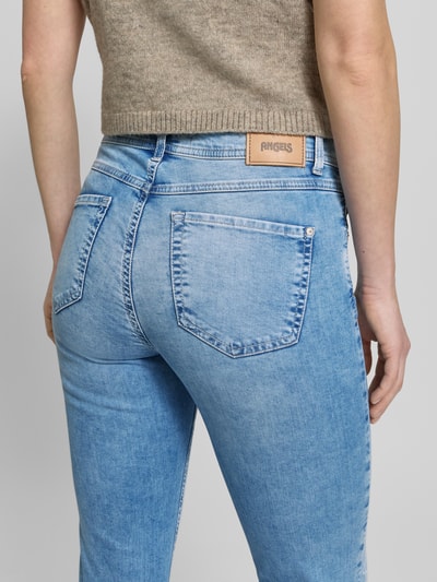 Frauenmodel trägt Slim Fit Jeans mit Strasssteinbesatz Modell 'Ornella Beauty' von Angels, hellblauer Baumwoll-Mix, 5-Pocket-Design, Strukturoptik, Körpernaher-Schnitt, Knopf-Reißverschluss, Bundweite 38 cm, Innenbeinlänge 67 cm, Ganzkörperansicht Rückansicht.
