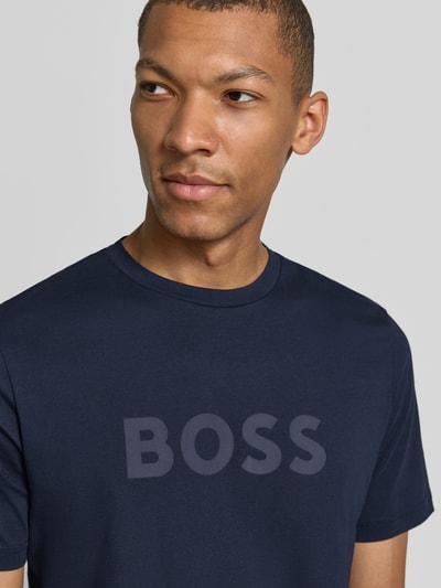 Männermodel trägt Regular Fit T-Shirt aus reiner Baumwolle Modell 'Te_Logo' von BOSS für BOSS Orange, Dunkelblau, Nahaufnahme Oberkörper.