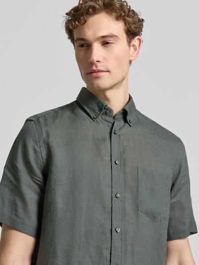 Männermodel trägt Regular Fit Freizeithemd aus Leinen von Christian Berg Men in Dunkelgrün, kurzärmelig, Button-Down-Kragen, Nahaufnahme Oberkörper.