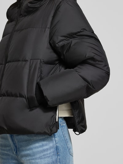 Frauenmodel trägt Regular Fit Daunenjacke mit Label-Patch von Marc O'Polo in Schwarz, glatte Textur, dezente Steppung, Nahaufnahme Oberkörper. Damen Daunenjacke von Marc O'Polo