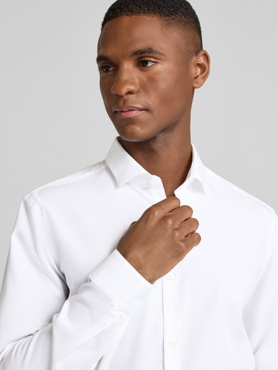 Männermodel trägt weißes Super Slim Fit Business-Hemd aus Baumwolle Modell 'Erondo' von HUGO, glatte Struktur, Nahaufnahme Oberkörper