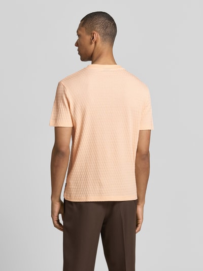 Männermodel trägt T-Shirt mit Strukturmuster Modell 'Raulos' von JOOP! Collection aus reiner Baumwolle, Modern Fit, Ganzkörperansicht Rückansicht.
