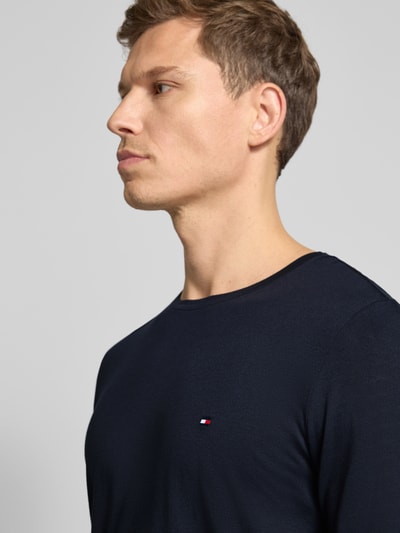 Männermodel trägt Slim Fit T-Shirt aus Baumwoll-Mix von Tommy Hilfiger, Optik: Unifarben, Logo-Detail, Jersey, Nahaufnahme Oberkörper.