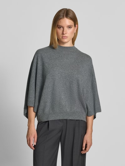 Frauenmodel trägt Relaxed Fit Pullover aus reinem Kaschmir in Strick-Optik von HERZENS, grauer Ton, elastischer Bund, Nahaufnahme Oberkörper.