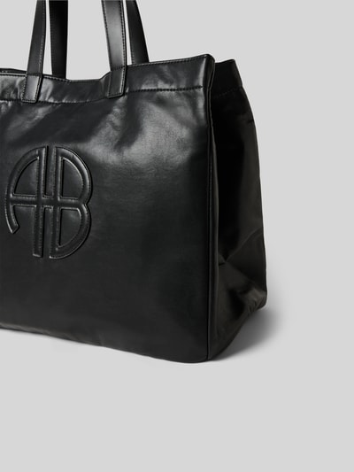 Produktfoto, Tote Bag mit Logo-Detail von Anine Bing in Schwarz mit Strukturmuster, offenem Hauptfach, Schulterriemen, Magnetverschluss, Maße: 43 cm Breite, 35 cm Länge, 22 cm Tiefe.