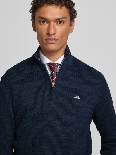 Männermodel trägt Strickpullover mit Stehkragen von Gant, Reine Baumwolle, Regular-Fit, Gerippte-Abschlüsse, Label-Stitching, Nahaufnahme Oberkörper.