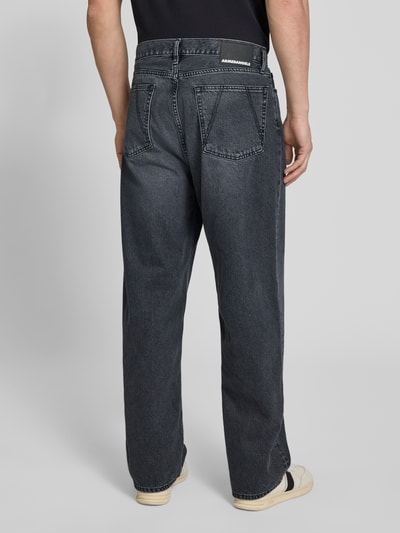 Männermodel trägt Loose Fit Baggy Jeans aus reiner Baumwolle Modell 'JAAMEO' von Armedangels in Denim-Optik mit Label-Patch, 5-Pocket-Design, verdecktem Knopfverschluss und Mid Waist Bundhöhe, Ganzkörperansicht Rückansicht.