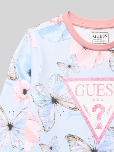 Meisjesmodel draagt Sweatshirt met Labeldetail van Guess in lichtblauw, puur katoen, regular fit, ribboorden, ronde hals, labeldetail. Nahaufnahme bovenlichaam.
