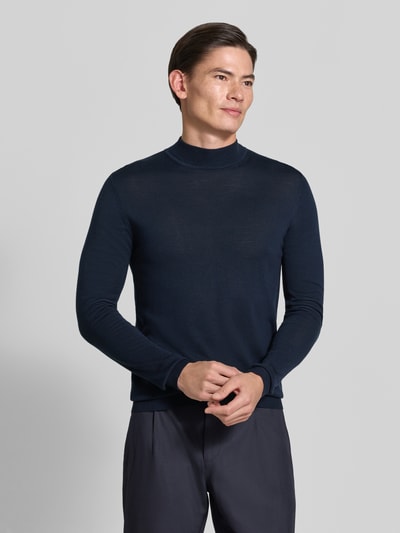 Männermodel trägt Slim Fit Strickpullover aus reiner Schurwolle mit Stehkragen von ROY ROBSON in Dunkelblau, elastische Abschlüsse, Ganzkörperansicht von vorne. Rückenlänge 69 cm, Ärmellänge 70 cm, glatte Textur.