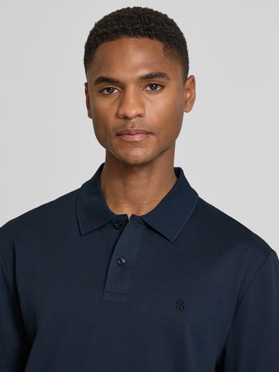 Männermodel trägt Regular Fit Poloshirt aus reiner Baumwolle Modell 'C-PARRIS' von BOSS, Optik: Unifarben, Logo-Stitching, Nahaufnahme Oberkörper.