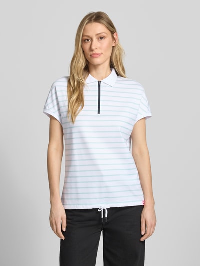 Frauenmodel trägt Regular Fit Poloshirt mit Reißverschluss von FIRE + ICE, Allover-Look, Tunnelzug, Modell GAJA2, Rückenlänge 62 cm, Ganzkörperansicht von vorne.