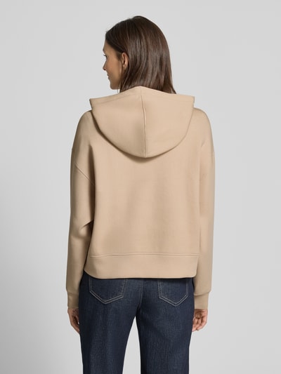 Frauenmodel trägt Oversized Hoodie aus Baumwoll-Mix von Lacoste Sport in Beige, unifarben, Sweat-Textur, Ganzkörperansicht Rückansicht.