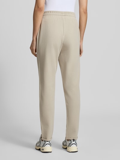 Vrouwenmodel draagt Regular Fit Sweathose uit katoenmix van JOOP! voor dames in lichtbeige, effen structuur, volledige achteraanzicht.
