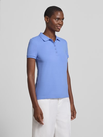 Frauenmodel trägt Slim Fit Poloshirt mit Knopfleiste von Christian Berg Woman, Baumwoll-Elasthan-Mix, zartes Blau, Seitenschlitze, Ganzkörperansicht von vorne. Rückenlänge bei Größe S: 62 cm.