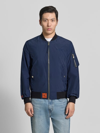 Mężczyznamodel nosi Bomberjacke mit Label-Patch und Eingrifftaschen od Original Bombers, granatowy kolor, prosta forma, gładka tekstura, całkowity widok z przodu