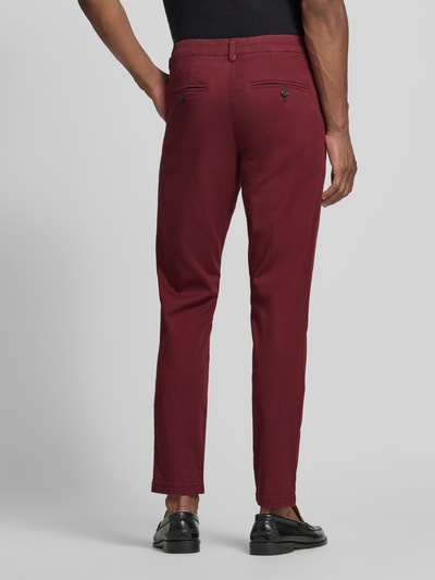 Männermodel trägt Slim Fit Chino aus Baumwoll-Mix Modell 'GABARDINE' von Selected in Dunkelrot, glatte Textur, Ganzkörperansicht Rückansicht. Herren Chino von Selected.