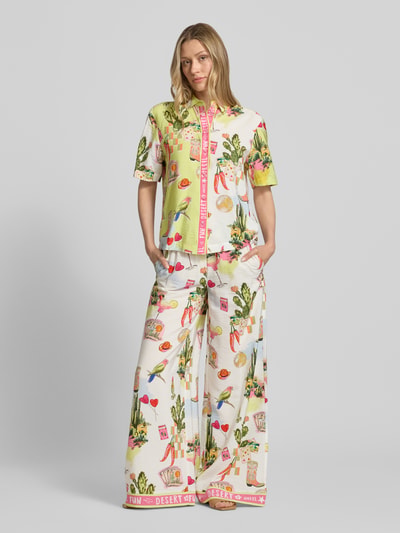 Frauenmodel trägt Bluse aus Viskose-Mix mit abgerundetem Saum von Marc Cain, Straight Fit, Kentkragen, Knopfleiste, buntes Muster, Rückenlänge bei Größe 36: 61 cm, Ärmellänge bei Größe 36: 25 cm, Ganzkörperansicht von vorne.