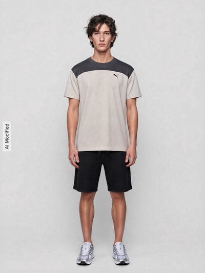 Männermodel trägt Regular Fit T-Shirt mit DryCell Technology Modell 'PUMATECH Essentials Tee' von PUMA in Beige und Schwarz, Herren T-Shirt von PUMA Performance, Ganzkörperansicht von vorne.