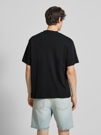 Männermodel trägt T-Shirt mit Rundhalsausschnitt Modell 'EURBAN EDGE' von Jack & Jones in Schwarz, Reine Baumwolle, Modern Fit, Rückenlänge 68 cm bei Größe M, Ganzkörperansicht Rückansicht.
