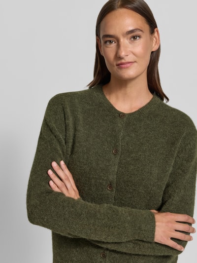 Frauenmodel trägt Regular Fit Cardigan aus Woll-Alpaka-Mix Modell 'NOR' von Samsøe Samsøe in Olivgrün, Strick-Optik, Nahaufnahme Oberkörper.