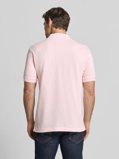 Männermodel trägt Regular Fit Poloshirt aus reiner Baumwolle von Lacoste in Hellrosa mit glatter Textur, Ganzkörperansicht Rückansicht.