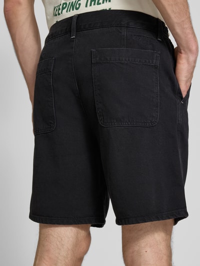 Männermodel trägt Loose Fit Jeansshorts aus Baumwoll-Mix von Marc O'Polo Denim in Schwarz, 5-Pocket-Design, Rückansicht, Nahaufnahme Oberkörper.