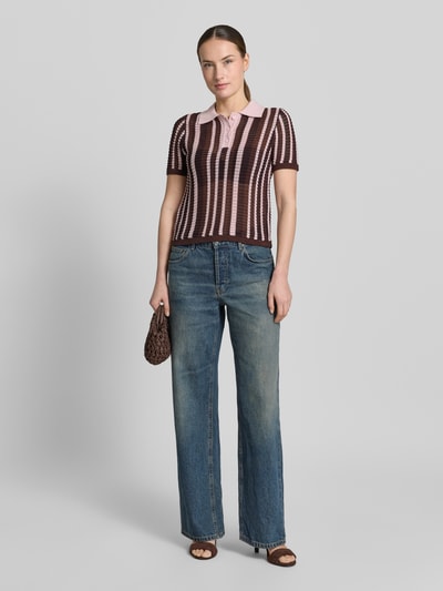 Frauenmodel trägt Modern Fit Poloshirt in Strick-Optik Modell 'PETRA' von Mango im Braun-Rosa-Streifenmuster, Baumwoll-Mix, Polokragen, kurze Knopfleiste, Rückenlänge 53 cm, Ärmellänge 23 cm, Ganzkörperansicht von vorne.