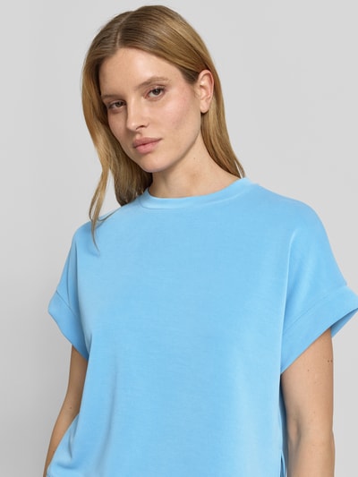 Modelka nosi Sweatshirt aus Modal-Mix mit Kappärmeln od Rich & Royal, mieszanka modalu z dodatkiem streczu, krój relaxed fit, okrągły dekolt, krótkie rękawy, damska bluza w jasnoniebieskim kolorze, gładka tekstura, zbliżenie na górną część ciała