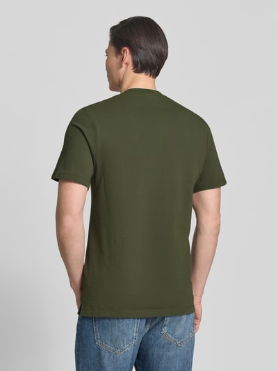 Männermodel trägt Regular Fit Poloshirt aus Baumwoll-Mix von s.Oliver RED LABEL in Olivgrün, Piqué-Struktur, Ganzkörperansicht Rückansicht.