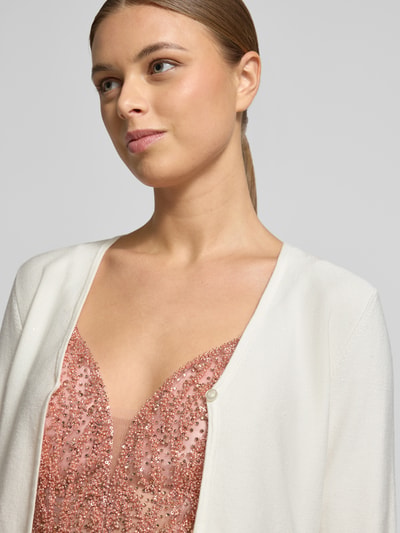 Vrouwenmodel draagt 'Bolero mit gerippten Abschlüssen' van Jake*s Cocktail, viscosemix, regular fit, V-hals, knoopsluiting, close-up bovenlichaam.