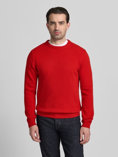 Męski model nosi Oversized Strickpullover mit gerippten Abschlüssen von Casual Friday, mieszanka wełny lana, prążkowane wykończenia, okrągły dekolt, długość tyłu w rozmiarze M 68 cm, długość rękawa w rozmiarze M 70 cm, kolor czerwony, gładka faktura, krój oversized, widok całej sylwetki z przodu.