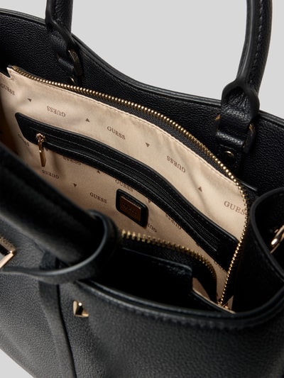 Productfoto, zwarte Handtasche mit Label-Applikation Modell 'ECO MERIDIAN II' van Guess met ritsvak, beige voering, structuurleer. Context: dameshandtas, hoofdvak met rits, draaghengsel, schouderriem, afmetingen 33x23x11 cm, schouderriem 106 cm.