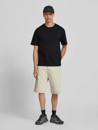 Männermodel trägt Regular Fit T-Shirt mit Rundhalsausschnitt von Jack & Jones aus Reine Baumwolle, Schwarz, 1/2-Arm, Ganzkörperansicht von vorne.