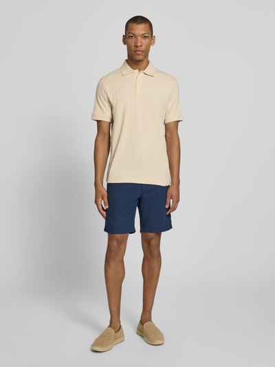 Männermodel trägt Regular Fit Poloshirt reiner Baumwolle Modell 'COLE' von SELECTED HOMME in Beige mit Struktur, Ganzkörperansicht von vorne.