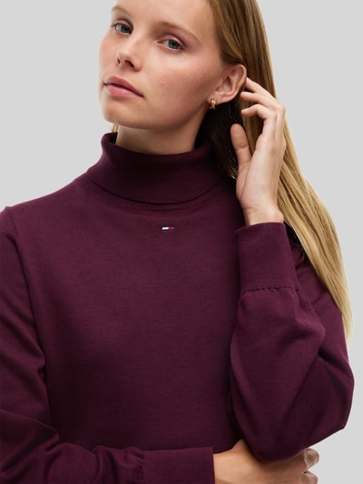 Kobiece modelka nosi 'Figurumspielendes Strickkleid aus reiner Baumwolle' od TOMMY JEANS, jednokolorowy, imitacja dzianiny, wyhaftowane logo, długi rękaw, bawełna, zbliżenie na górną część ciała.