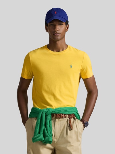 Männermodel trägt Regular Fit T-Shirt aus reiner Baumwolle von Polo Ralph Lauren in Unifarbe Gelb mit Logo-Stitching; Ganzkörperansicht von vorne.