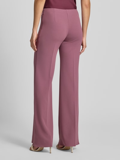 Frauenmodel trägt Flared Fit Stoffhose mit Bügelfalten von Rinascimento in Altrosa, glatte Textur, elastischer Bund, Ganzkörperansicht Rückansicht.