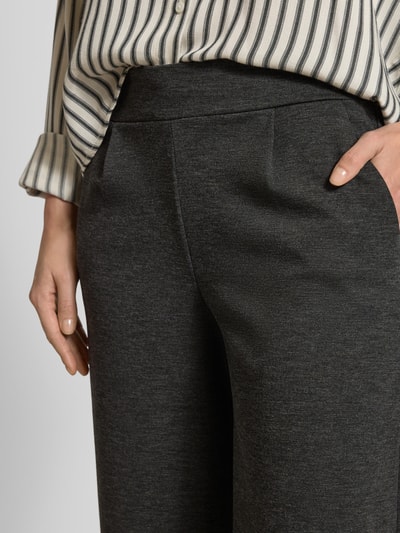Kobieta nosi Stoffhose mit Eingrifftaschen od ICHI, ciemnoszary kolor, luźny krój, elastyczny pas, zbliżenie na górę spodni.