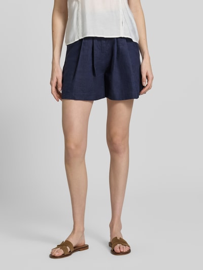 Kobiece model prezentuje 'Leinenshorts mit Eingrifftaschen' od Stefanel, len, krój straight fit, granatowy, zapięcie na haftkę i zamek błyskawiczny, wpuszczane kieszenie, imitowane tylne kieszenie z wypustką, szerokość w rozmiarze 36: 33 cm, długość wewnętrzna nogawki w rozmiarze 36: 11 cm, widok całej sylwetki z przodu.