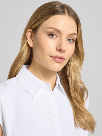 Frauenmodel trägt Hemdblusenkleid mit Gürtel und Knopfleiste von MICHAEL Michael Kors in Weiß, reine Baumwolle, Nahaufnahme Oberkörper.