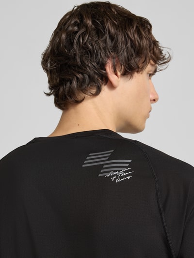 Männermodel trägt schwarzes Regular Fit Sport-T-Shirt mit Logo-Print Modell 'PWRMODE' von PUMA Performance, Nahaufnahme Rückansicht.