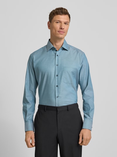 Männermodel trägt Regular Fit Businesshemd aus Baumwolle mit Kentkragen von Eterna in Hellblau, Knopfleiste, Brusttasche, Ganzkörperansicht von vorne. Rückenlänge 80 cm, Schulterbreite 49 cm, Ärmellänge 65 cm bei Größe 40.